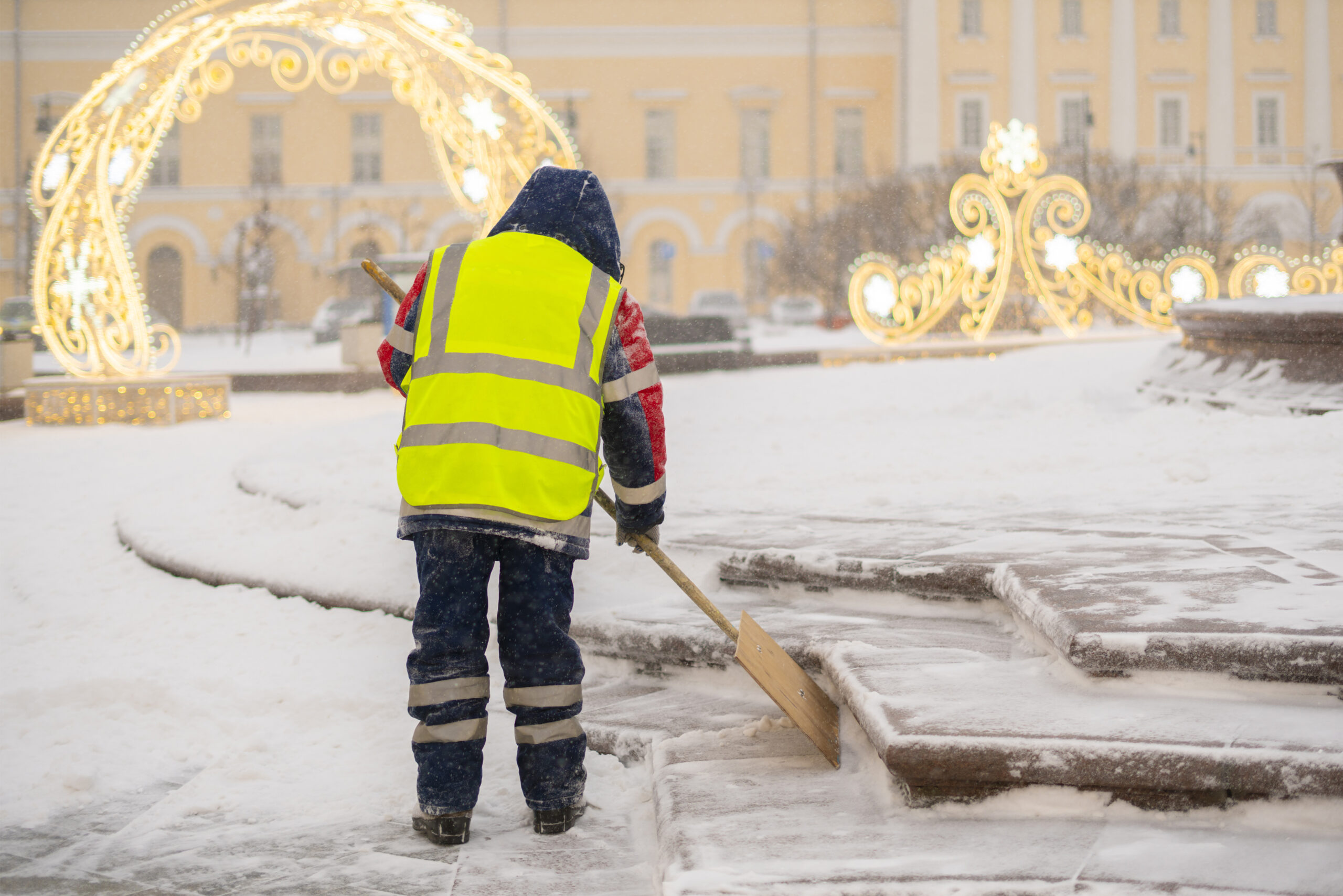 city service guy clean snow from streets with shovel