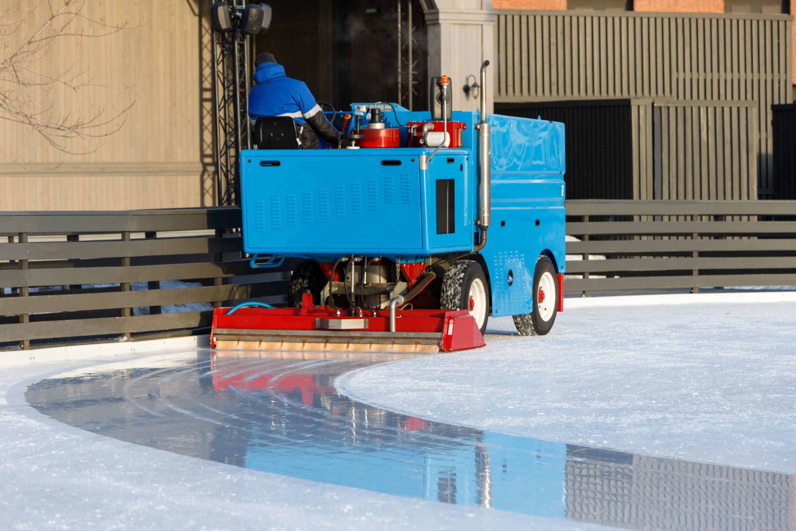 ice preparation at the rink between sessions in the sunny winter day/ Polished ice ready for match
